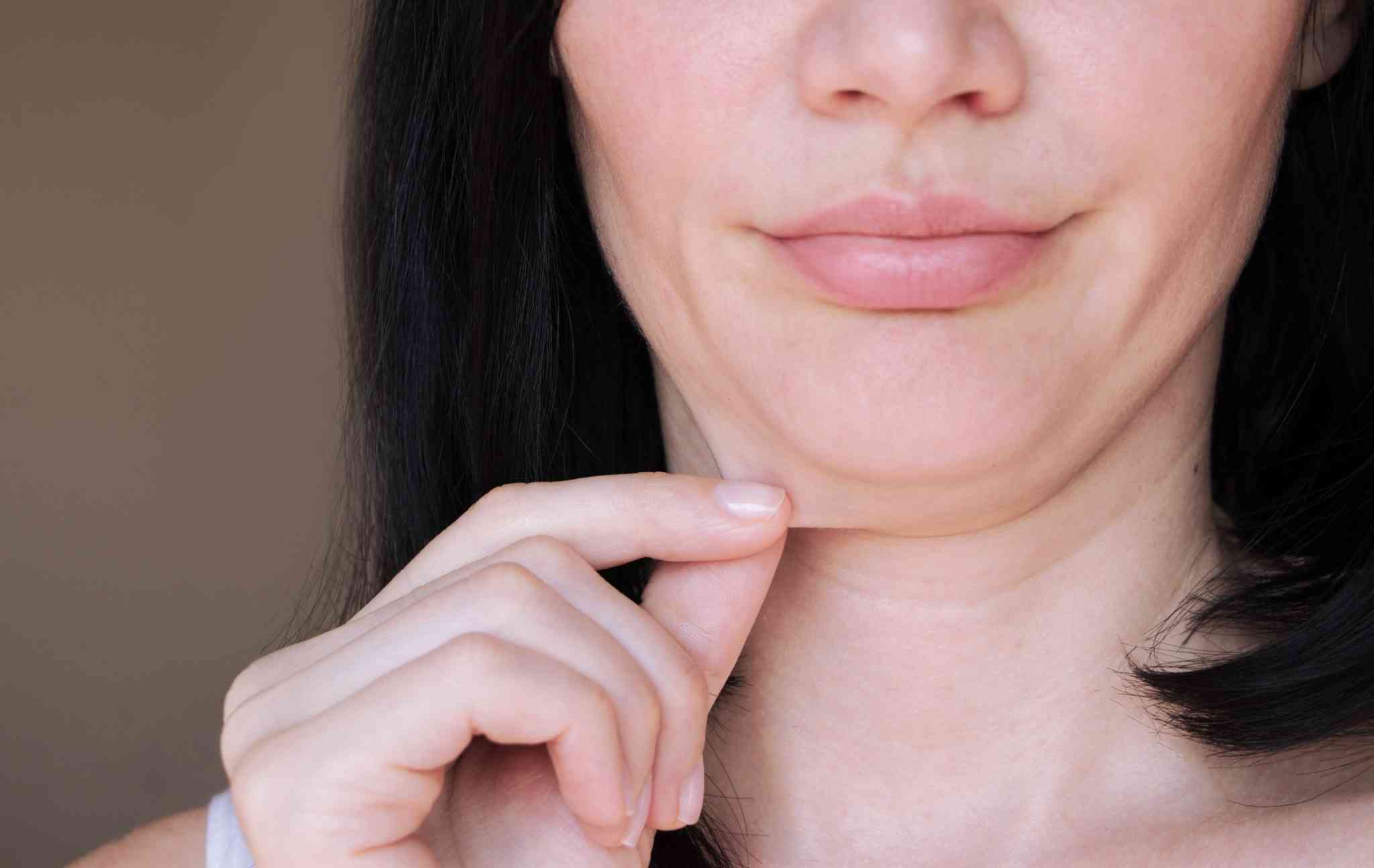 Close-up of a woman pinching her neckline.