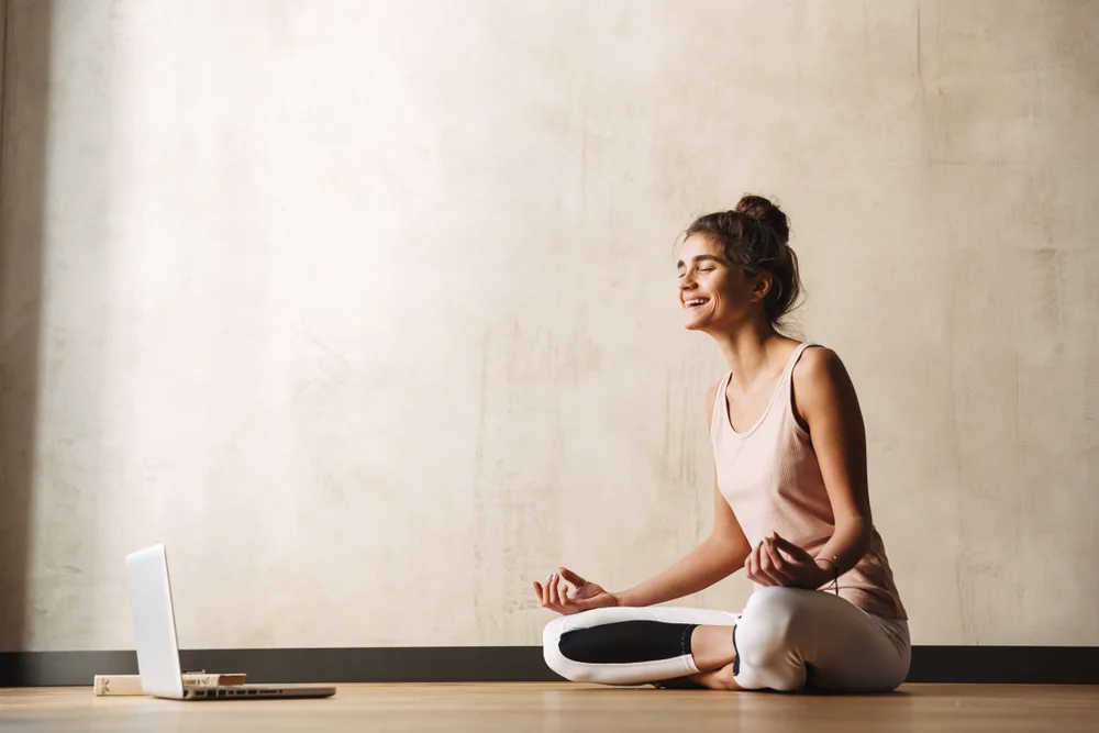 A woman listening to recorded sound bath music on her laptop