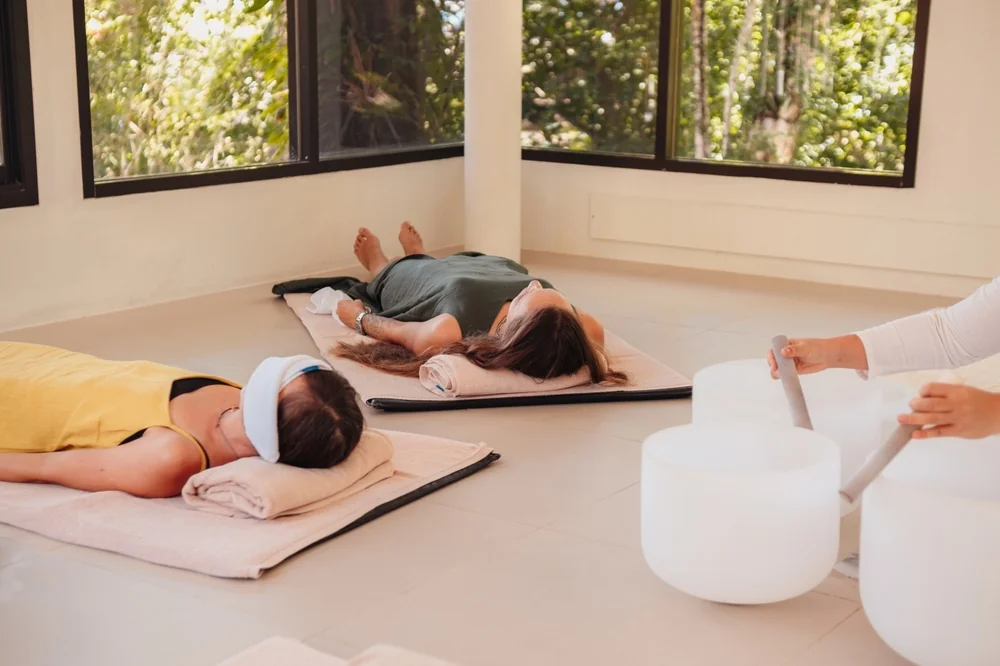 Participants with towels over their eyes experiencing a sound bath