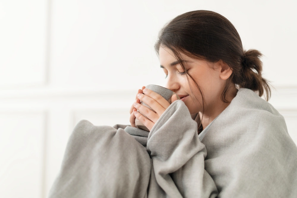 A lady being mindful by enjoying a cup of hot drink