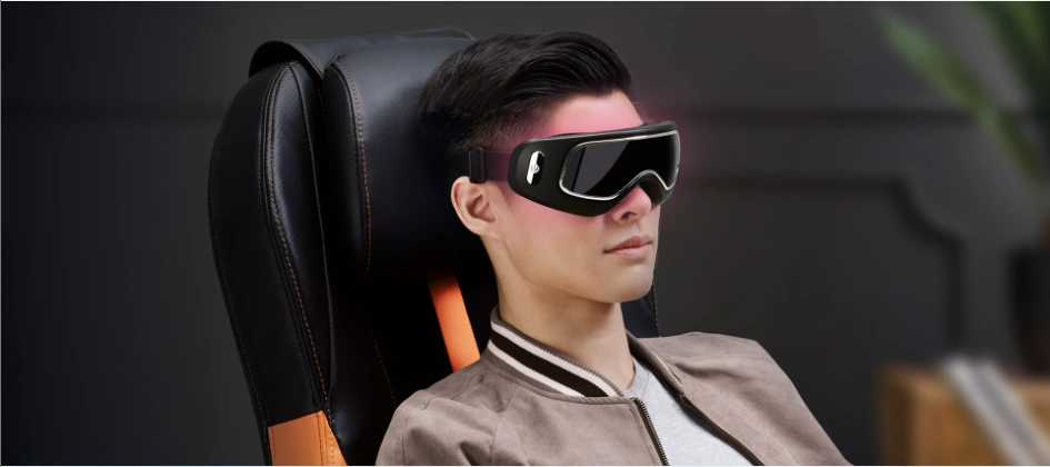 A man using uVision 3 Eye Massager to relax his eyes after work