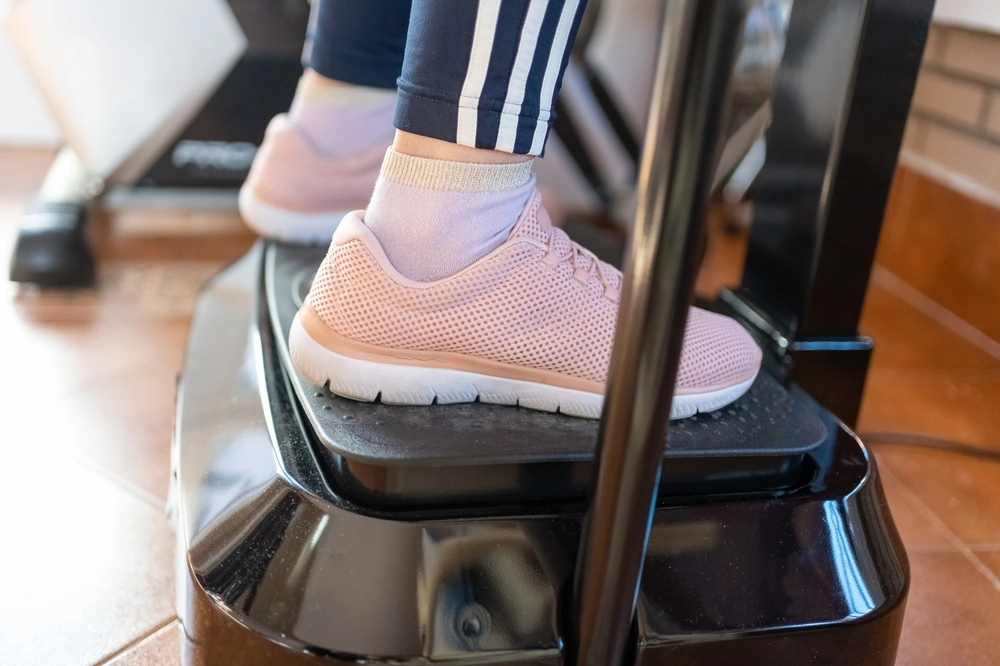 Close-up of a woman’s feet on a vibrating plate