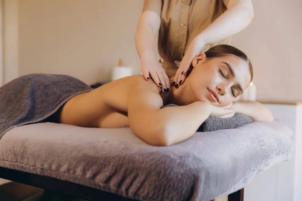Professional massage therapist working on client's neck and shoulders